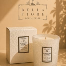 Two decorative scented candles in textured glass containers with a matching box