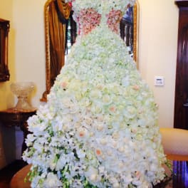 Large white and blush floral gown-shaped arrangement on a table