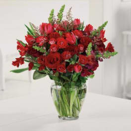 Red mixed flower bouquet in a clear glass vase