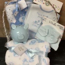 Baby gift basket with blue blankets, bibs, and a piggy bank