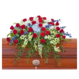 Red roses and white flowers arranged on a wooden casket