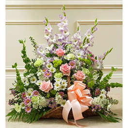 Basket arrangement of pink roses, daisies, and tall lavender flowers with a peach ribbon