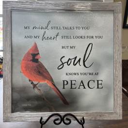 Framed memorial sign with a red cardinal and peace message