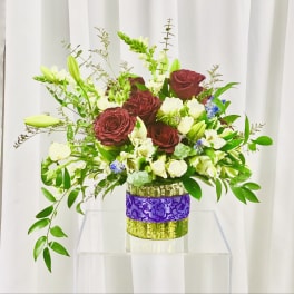 Bouquet of burgundy roses and white flowers in a glass vase