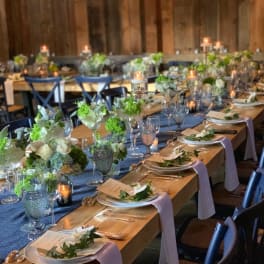 Long banquet tables with white floral centerpieces and candles