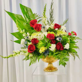 Red and white roses arranged in a gold pedestal vase