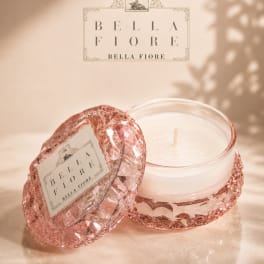 Pink glass candle jar with a white candle and matching lid