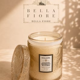 Decorative jasmine-scented candle in a glass jar with a patterned lid
