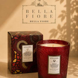 Red scented candle in a decorative glass jar with matching box