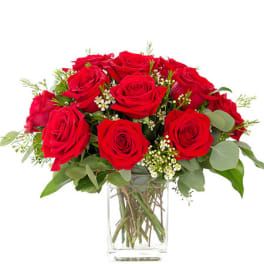 Red roses arranged in a clear glass vase