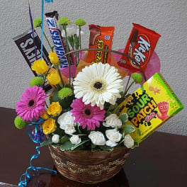 Basket arrangement with gerbera daisies, roses, and candy bars