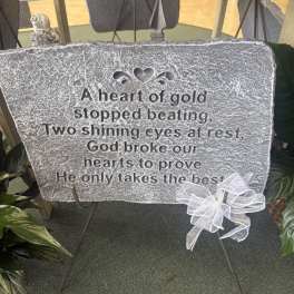 Memorial plaque on an easel with a white ribbon bow