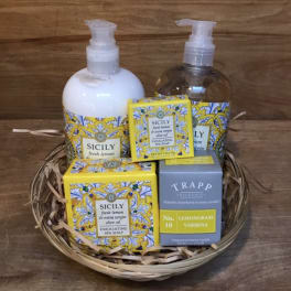 Gift basket with soap, lotion, and a candle in decorative boxes