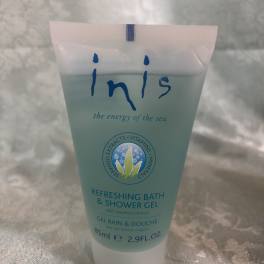 Tube of Inis refreshing bath and shower gel on a fabric surface