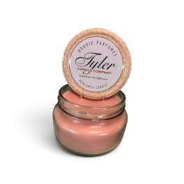 Pink scented candle in a glass jar with a lid