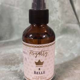 Amber room spray bottle with a black pump and pink label