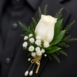 White rose boutonniere with small white flowers on a black jacket