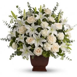 White lilies and cream roses arranged in a brown urn