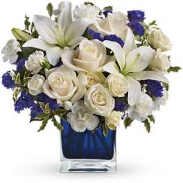 White lilies and roses in a blue glass vase