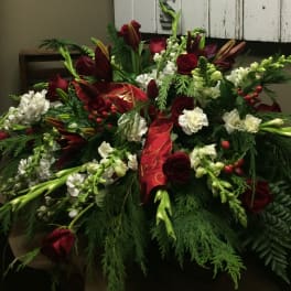 Red roses and white flowers arranged with a red ribbon