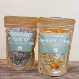 Two pouches of soaking salts with dried flowers on a wooden surface