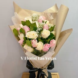 Bouquet of pink and white roses wrapped in beige paper