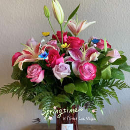 Pink roses and lilies arranged in a glass vase