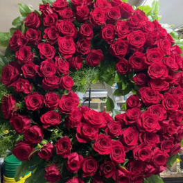 Large circular wreath of red roses with green foliage