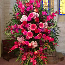 Tall standing spray of pink and red flowers on an easel