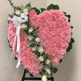 Heart-shaped pink floral standing spray with white roses and ribbon