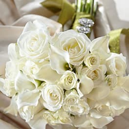 White roses and calla lilies arranged in a bouquet