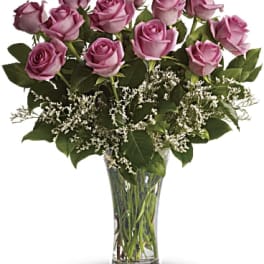 Lavender roses arranged in a clear glass vase
