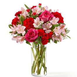 Pink roses and red carnations in a clear glass vase