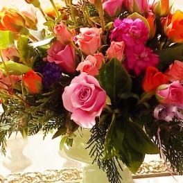 Mixed bouquet of pink and orange roses in a white vase
