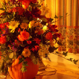 Large mixed flower arrangement in a pumpkin-shaped container