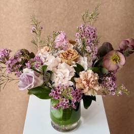Mixed bouquet of pink and cream flowers in a glass vase