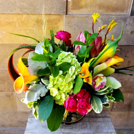 Colorful bouquet with roses, hydrangea, calla lilies, and orchids in a vase