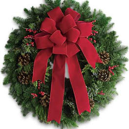 Christmas wreath with a large red bow and pinecones