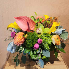 Colorful mixed floral arrangement with calla lilies, anthurium, and dahlias in a vase