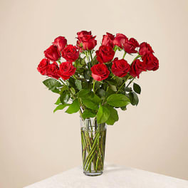 Red roses arranged in a clear glass vase