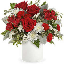Red roses and white daisies arranged in a white vase