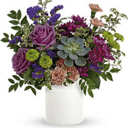 Purple and pink floral arrangement in a white vase
