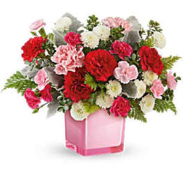 Pink and red carnations in a pink glass vase