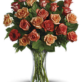 Bouquet of peach and red roses in a clear glass vase