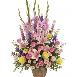 Tall mixed flower arrangement in a decorative vase with pink lilies and roses