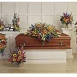 Casket surrounded by colorful funeral flower sprays and wreaths