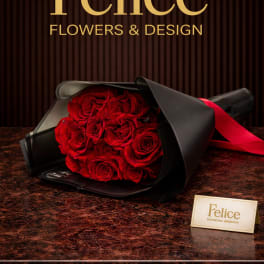 Bouquet of red roses wrapped in black paper with a red ribbon
