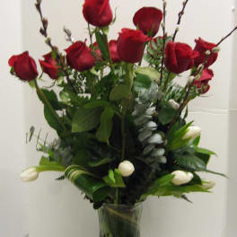 Red roses and white tulips in a clear glass vase