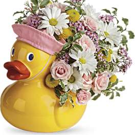 Yellow duck-shaped vase filled with pink and white flowers