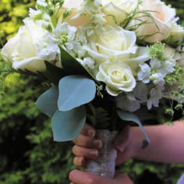 White rose bouquet with small white flowers and blue-green leaves